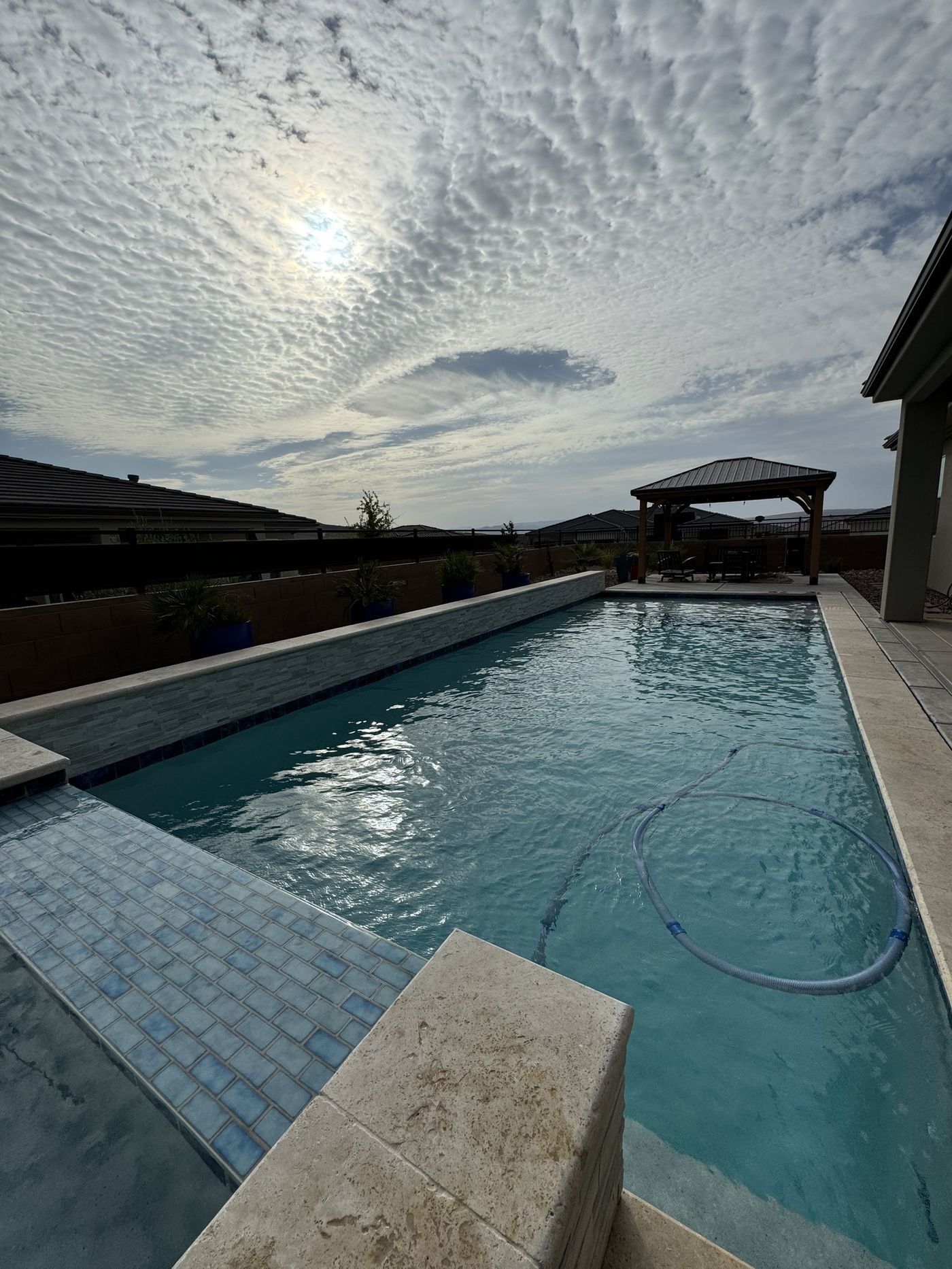 Clean residential pool at dusk with pergola and mountain views in St. George, UT
