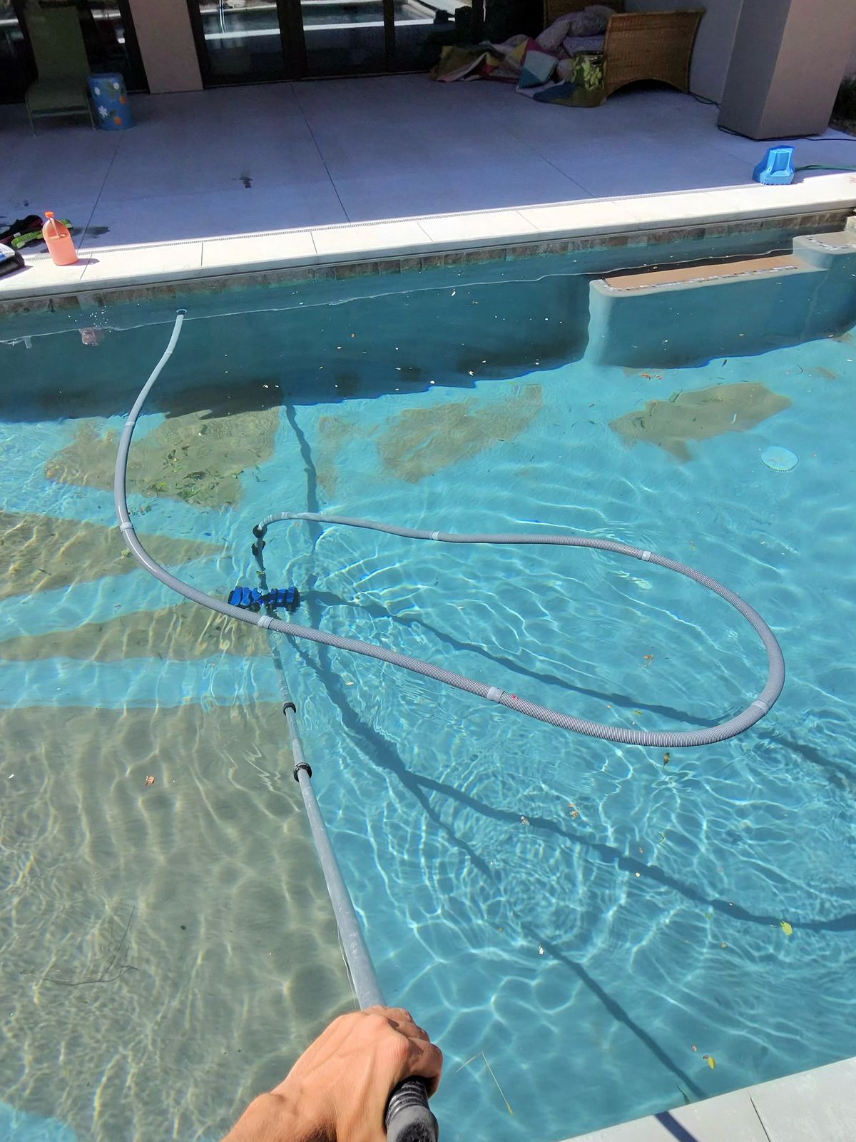 Endless Summer technician vacuuming a pool to crystal-clear water in St. George, UT
